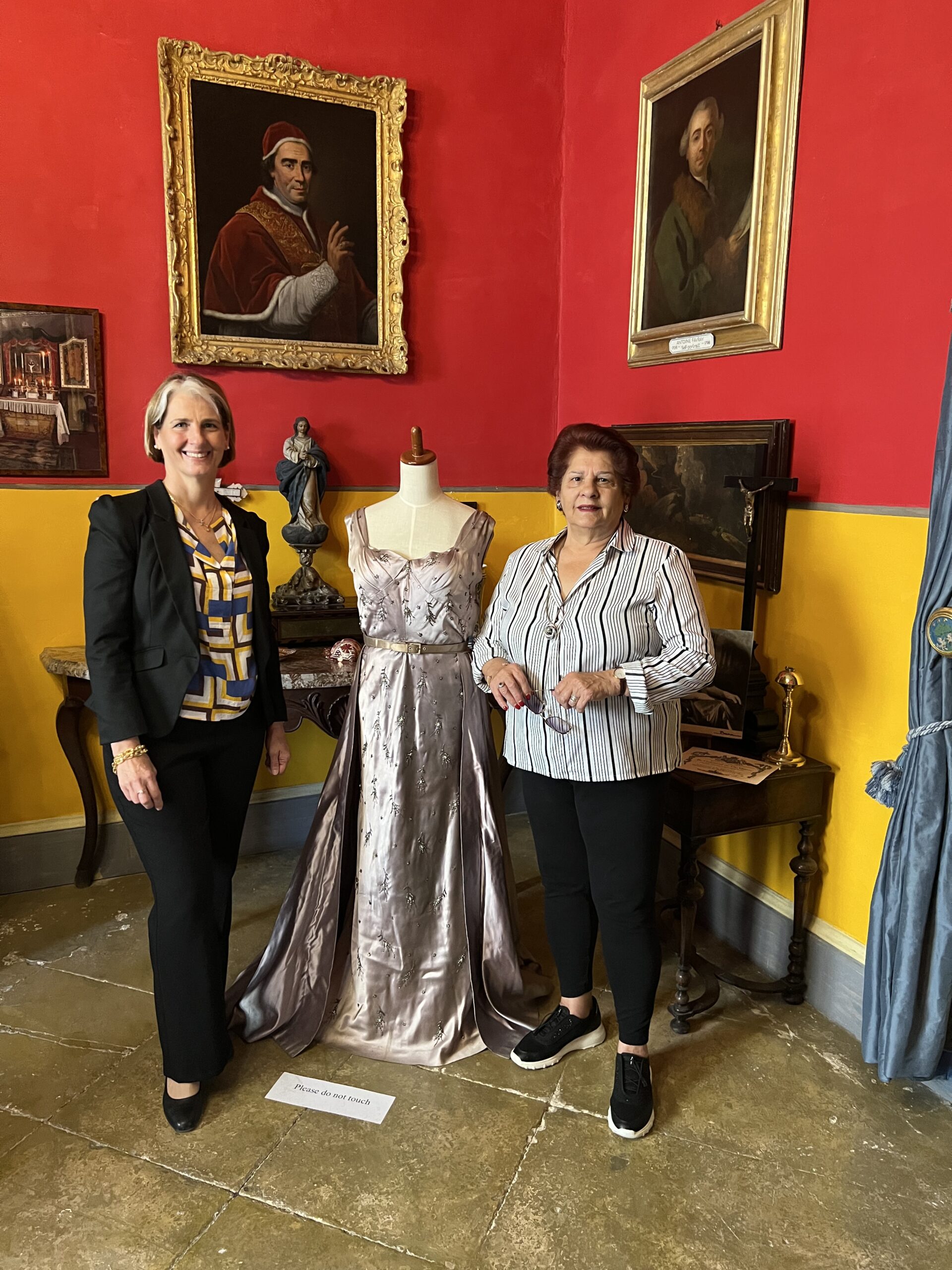 Caroline Tonna displays the Worth silk evening dress worn by Phyllis de Piro for the Coronation of Queen Elizabeth II in 1953, with her mum Carmen Camilleri